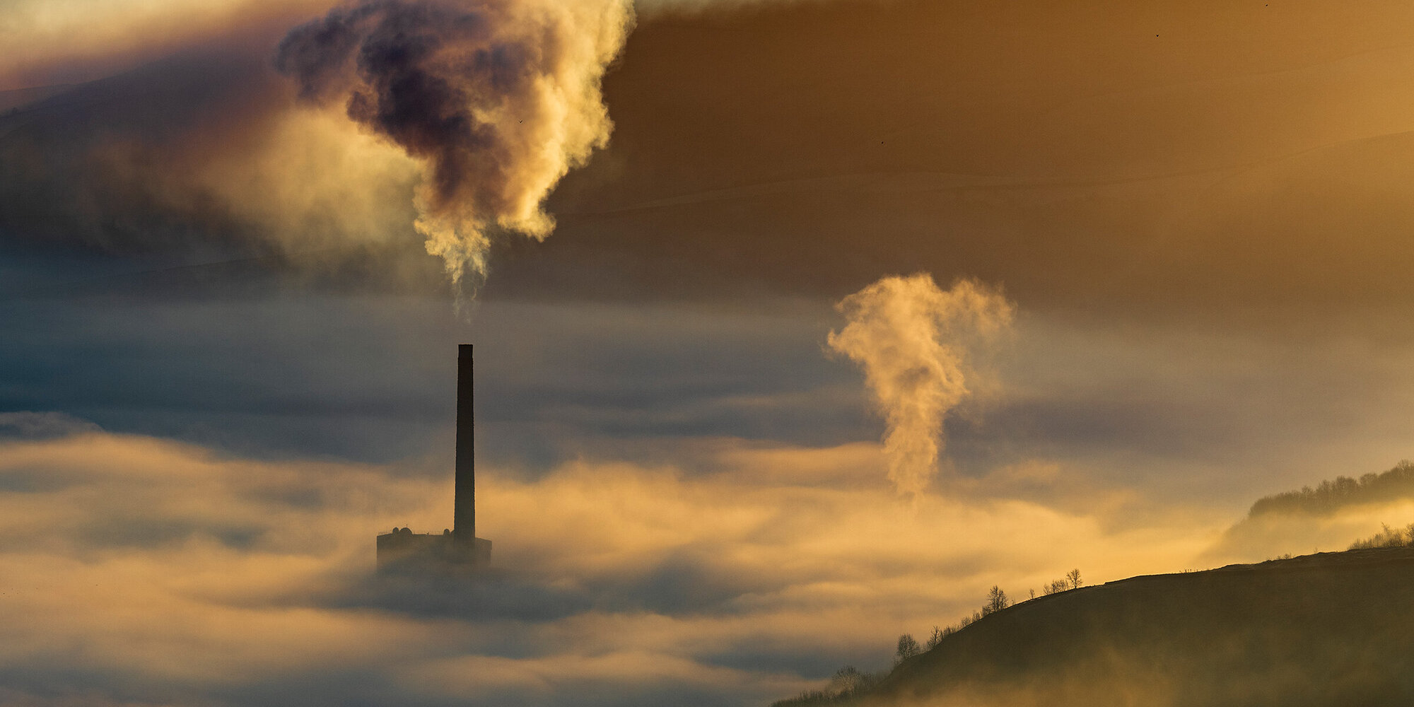 Hope valley and Castleton on a stunning misty morning with the pollution of the local cement factory.  Peak District National park. Derbyshire.