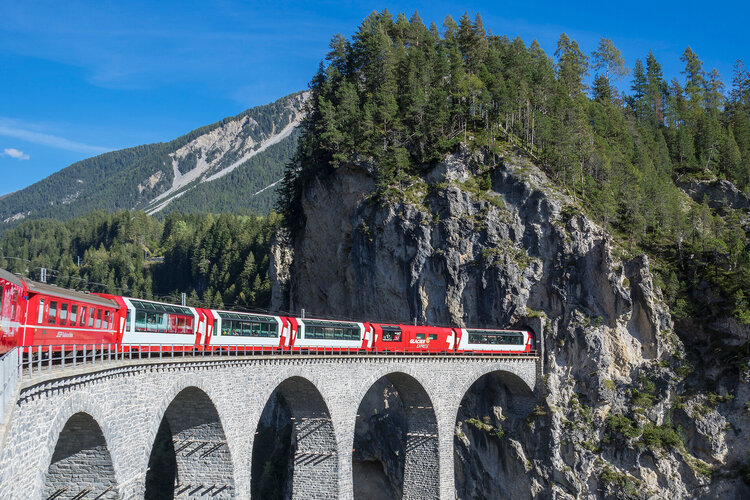 Zug der rhätischen Bahn fährt über ein Viadukt