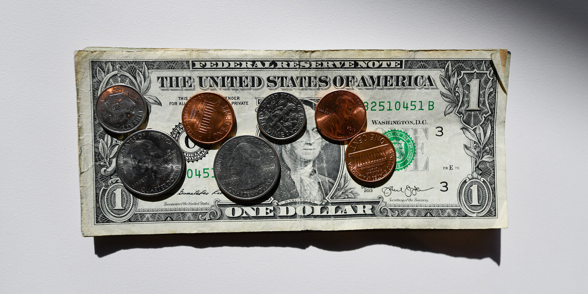 Ein Symbolbild: Cents auf einer Dollar Note