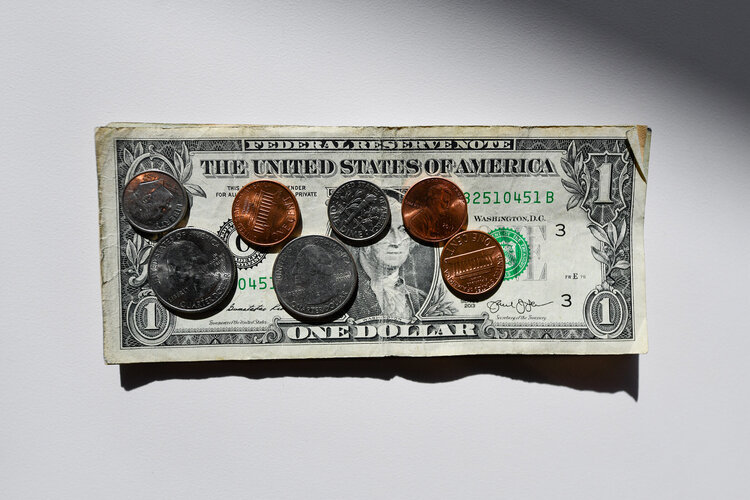 Ein Symbolbild: Cents auf einer Dollar Note