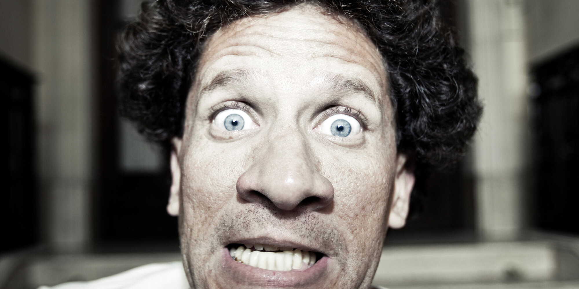Crazy mad man in straightjacket with wide open eyes looking scared and furious. Personal Editing. Squared.