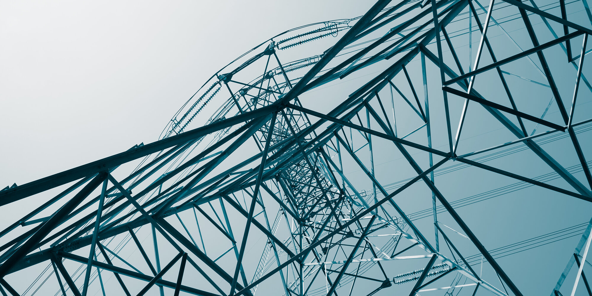 Abstract pattern from bottom view of high voltage pole power transmission tower with clear sky sunny day background in monochrome tone. Green energy, environmental conservation concept.