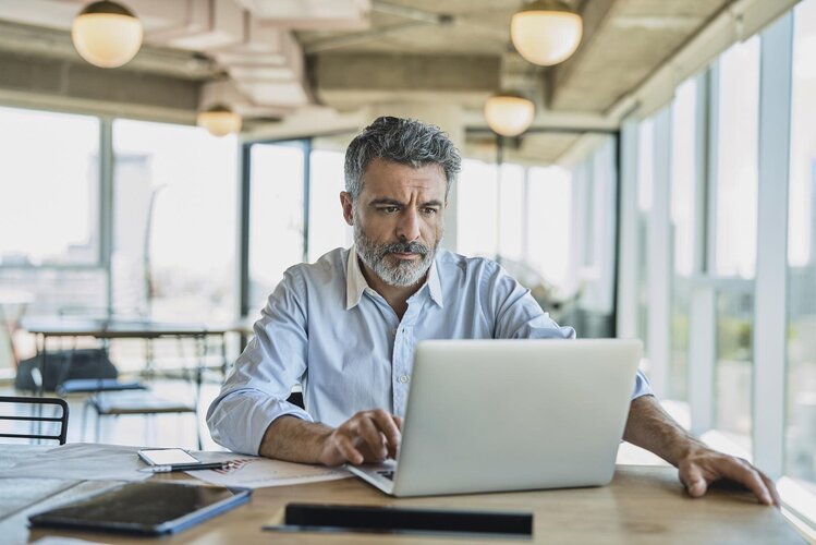 Mann am Schreibtisch mit Laptop