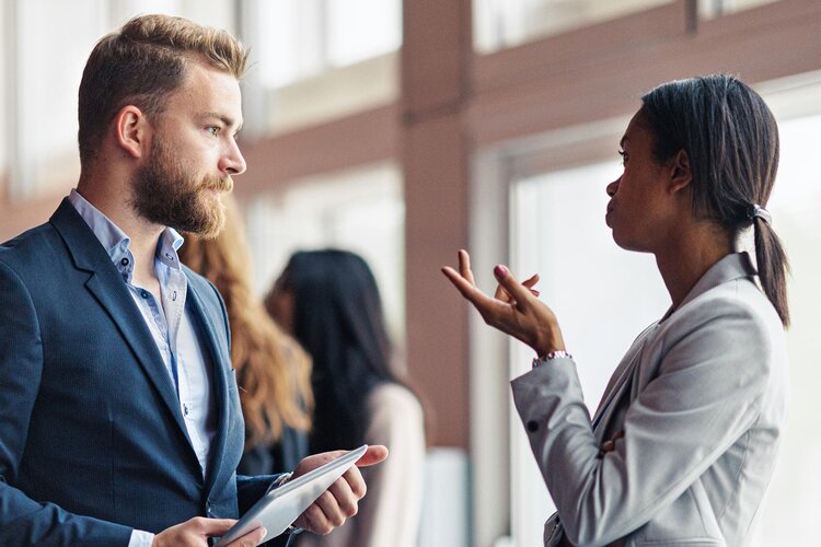 Ein Mann und eine Frau im Business Look sprechen miteinander