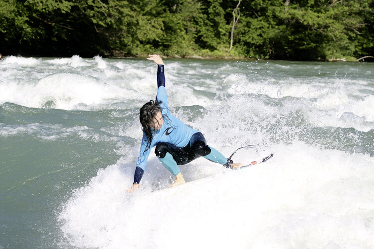 Flusssurferin auf einer Welle im Fluss
