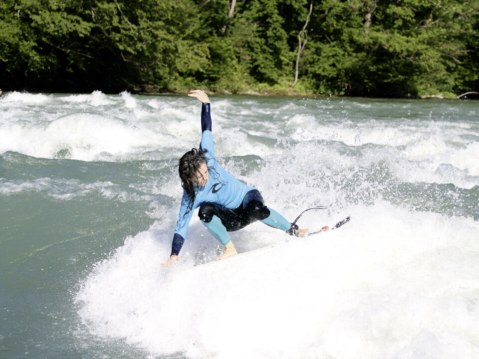 Flusssurferin auf einer Welle im Fluss