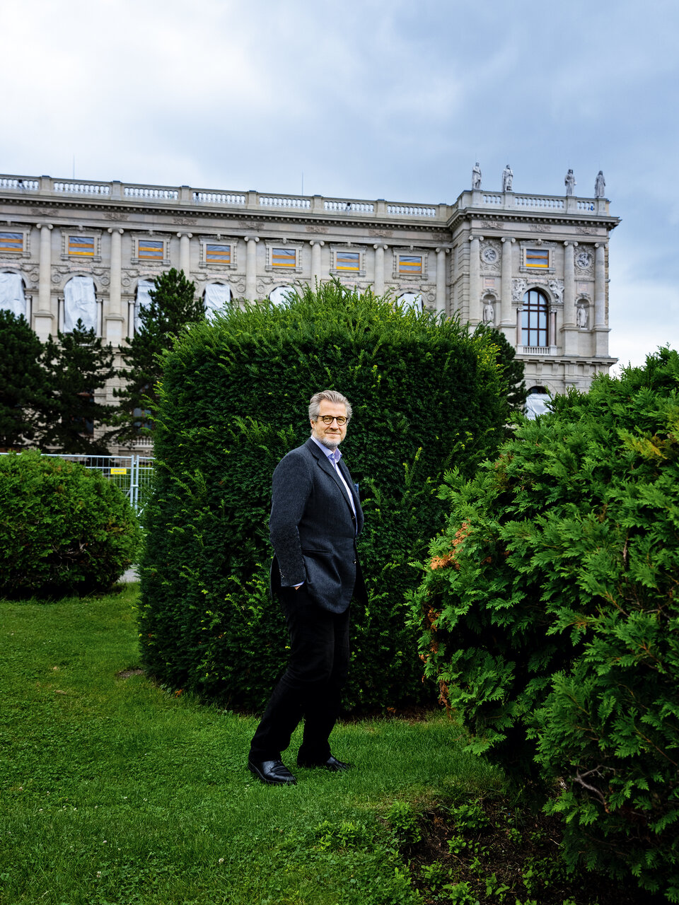 Philipp Blom in einem Park, im Hintergrund ein Gebäude