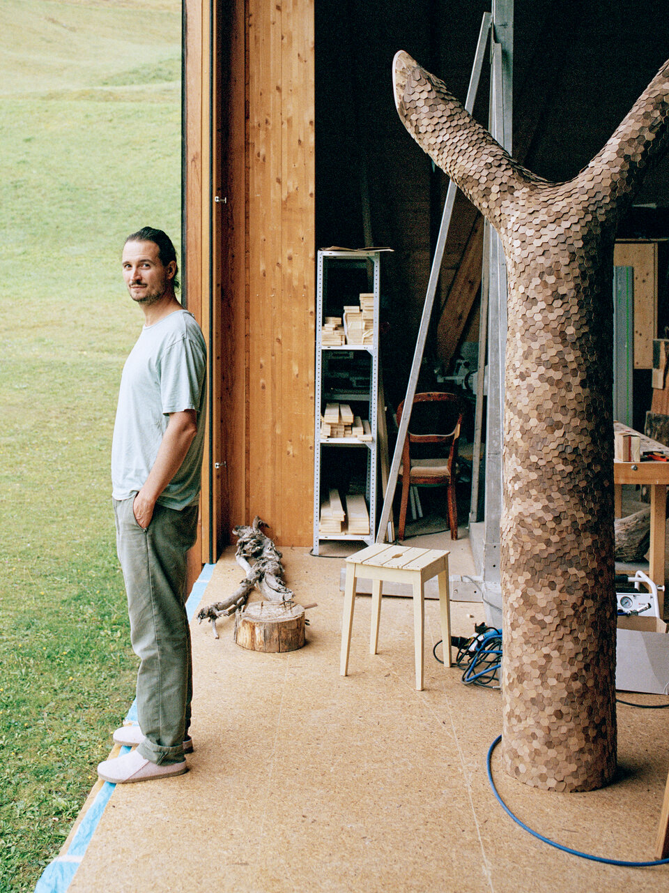 Das Bild zeigt Künstler Mirko Baselgia stehend in seinem Atelier im bündnerischen Alvaschein.