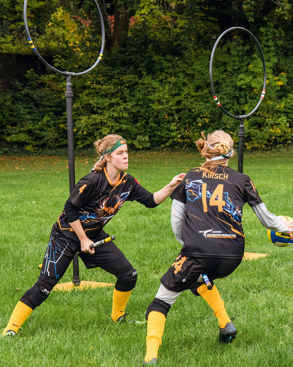 Das Bild zeigt zwei Spielerinnen der Quidditch-Mannschaft Turicum Thunderbirds während eines Spiels.