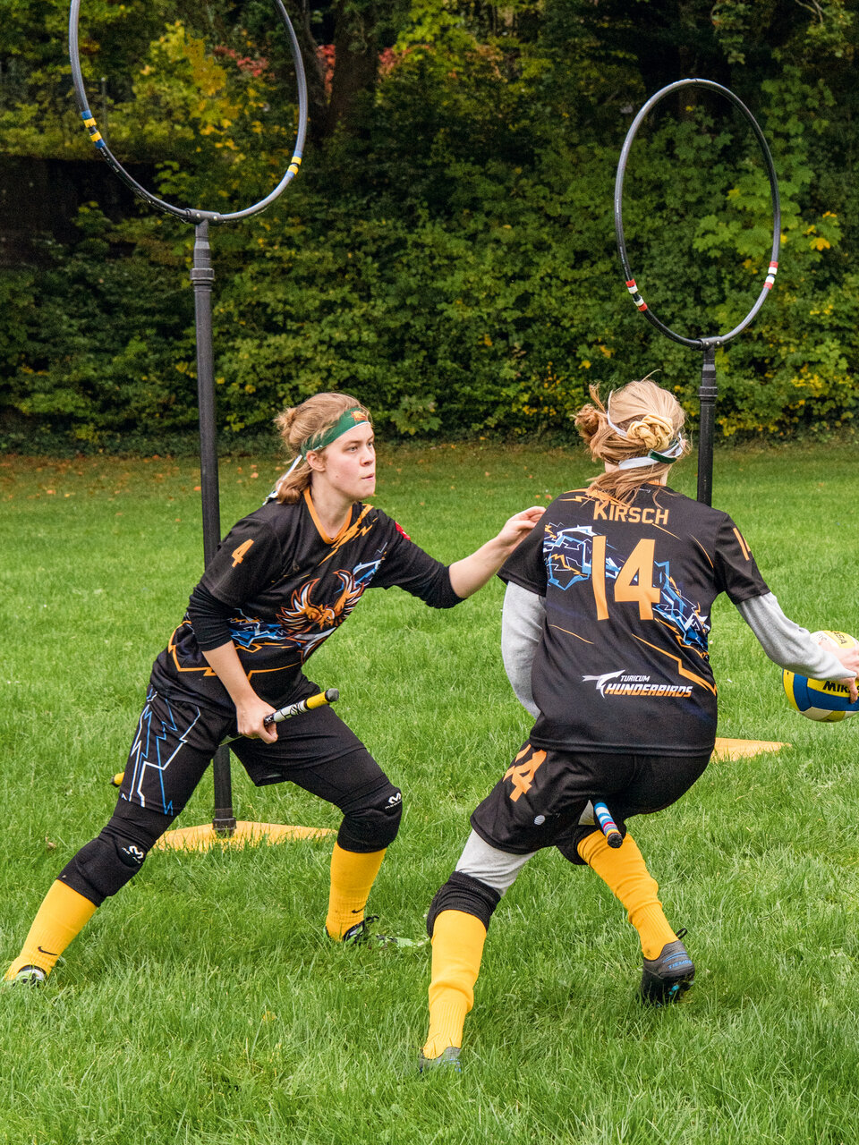 Das Bild zeigt zwei Spielerinnen der Quidditch-Mannschaft Turicum Thunderbirds während eines Spiels.